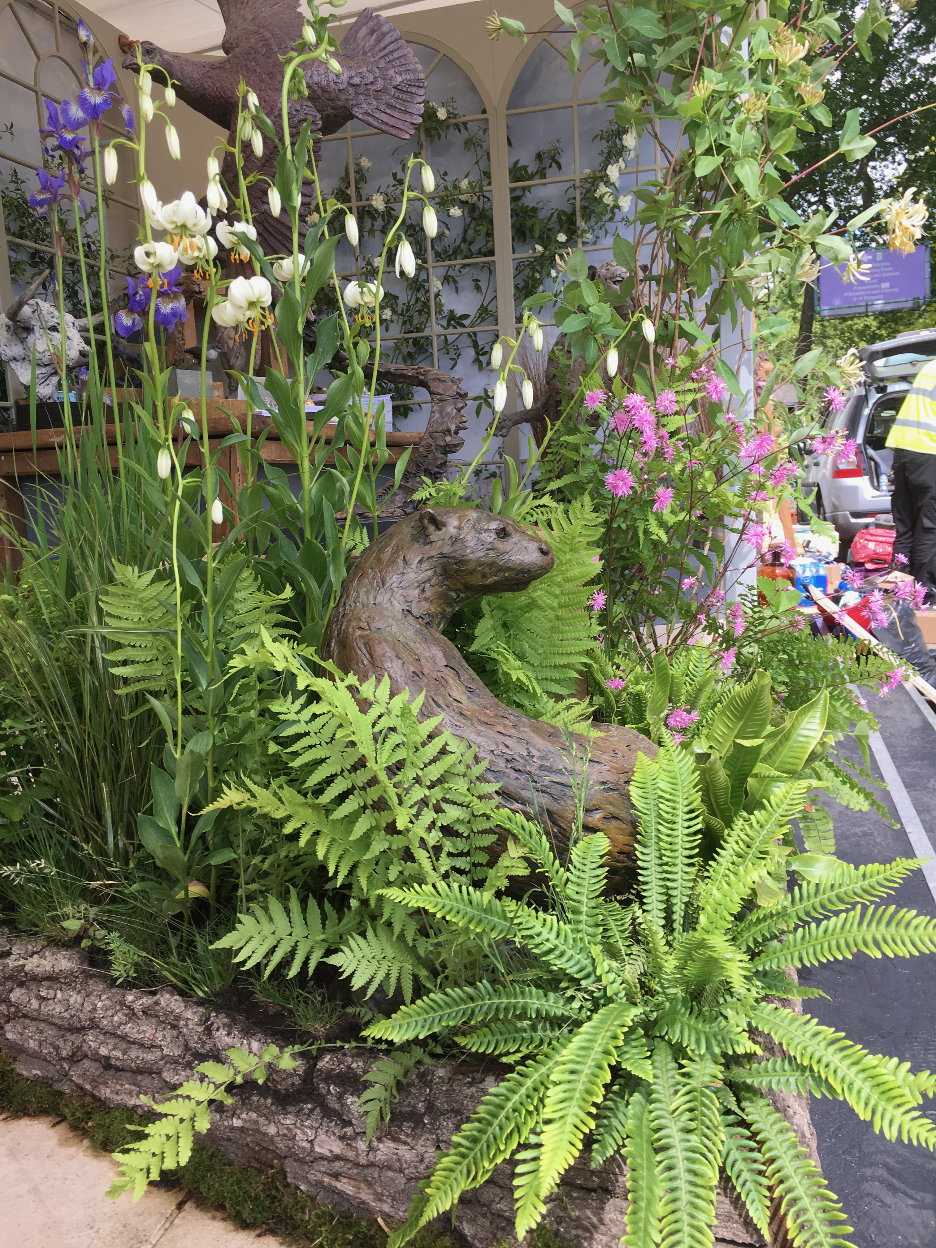 Hamish mackey otter sculpture nessaled within chelsea flower show planting 
